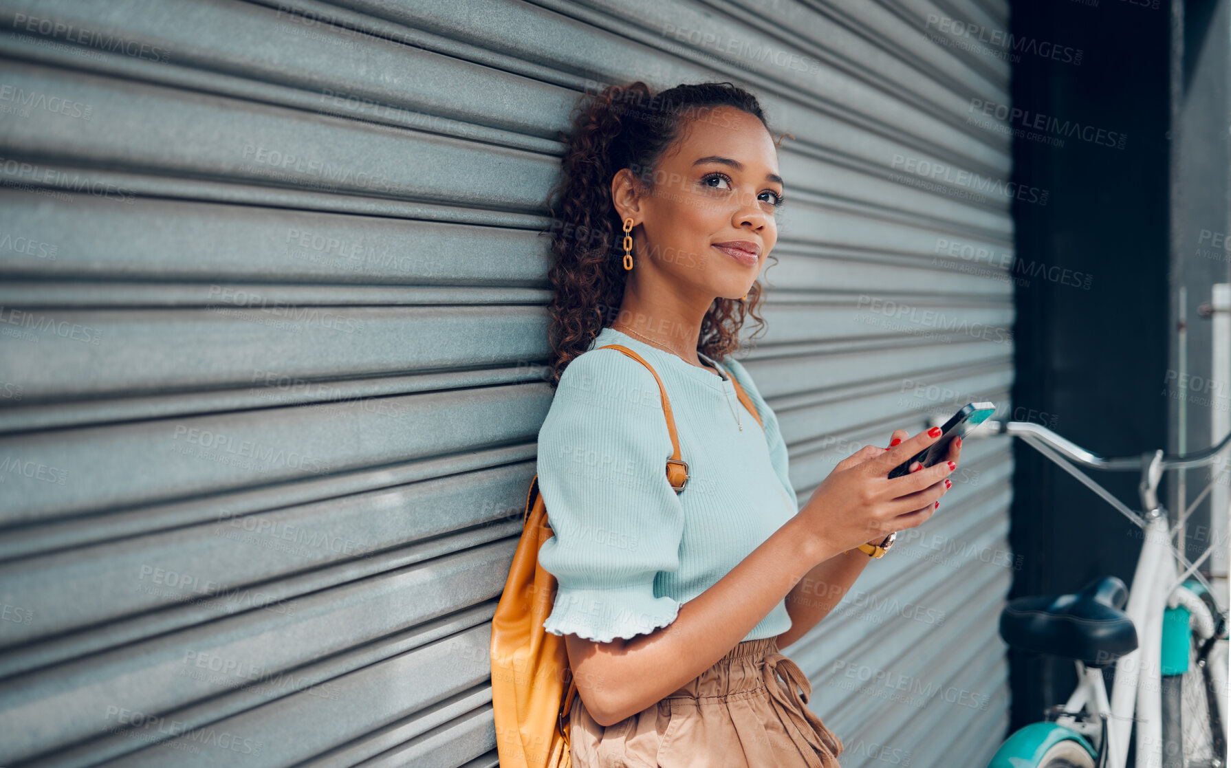 Buy stock photo City lifestyle, girl with phone and bike standing at wall thinking before writing text. Happy female student, bicycle and smartphone outside street, communication, 5g and sustainable urban transport.