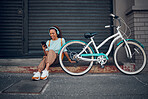 Bike, woman and headphone with phone in city relax, with bicycle and happy texting, social media apps and chat. Girl, lady and with eco friendly transportation, trendy or edgy look sit on sidewalk