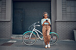 Headphone, woman and phone with bicycle in city listening to music or podcast streaming outdoor in summer with trendy look. Eco friendly transportation for carbon footprint bike using 5g network