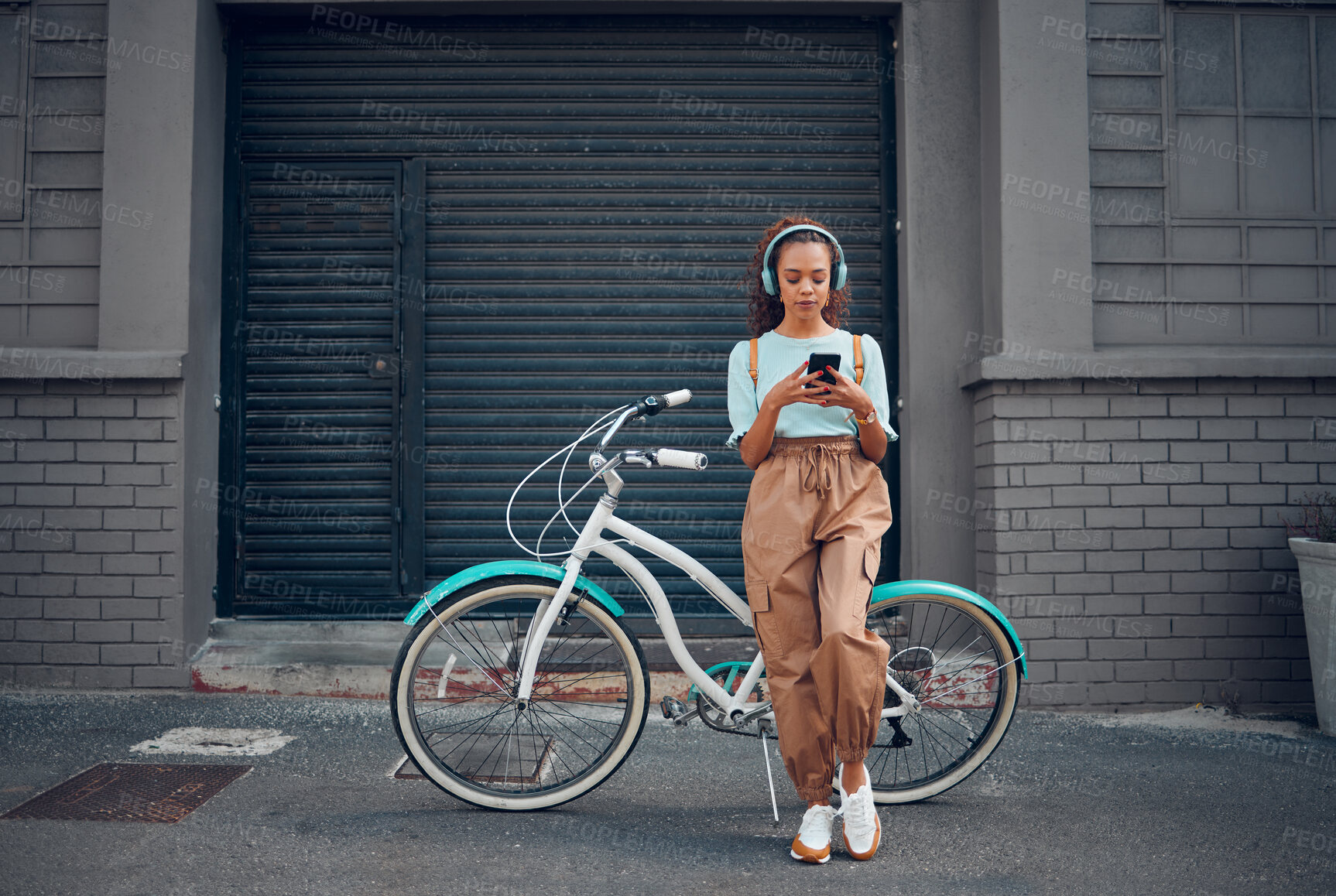 Buy stock photo Headphone, woman and phone with bicycle in city listening to music or podcast streaming outdoor in summer with trendy look. Eco friendly transportation for carbon footprint bike using 5g network
