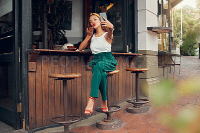 Buy stock photo Restaurant, woman and influencer taking a phone selfie for social media content for online followers outdoors. Lifestyle, cafe and young person blowing a kiss on a photo enjoying summer holidays 