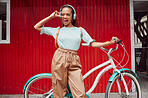 Girl with headphones, bicycle and red background in the city, listening to music. Summer, young and happy black woman with smile on face, peace hand sign and bike in urban town and earphones for song