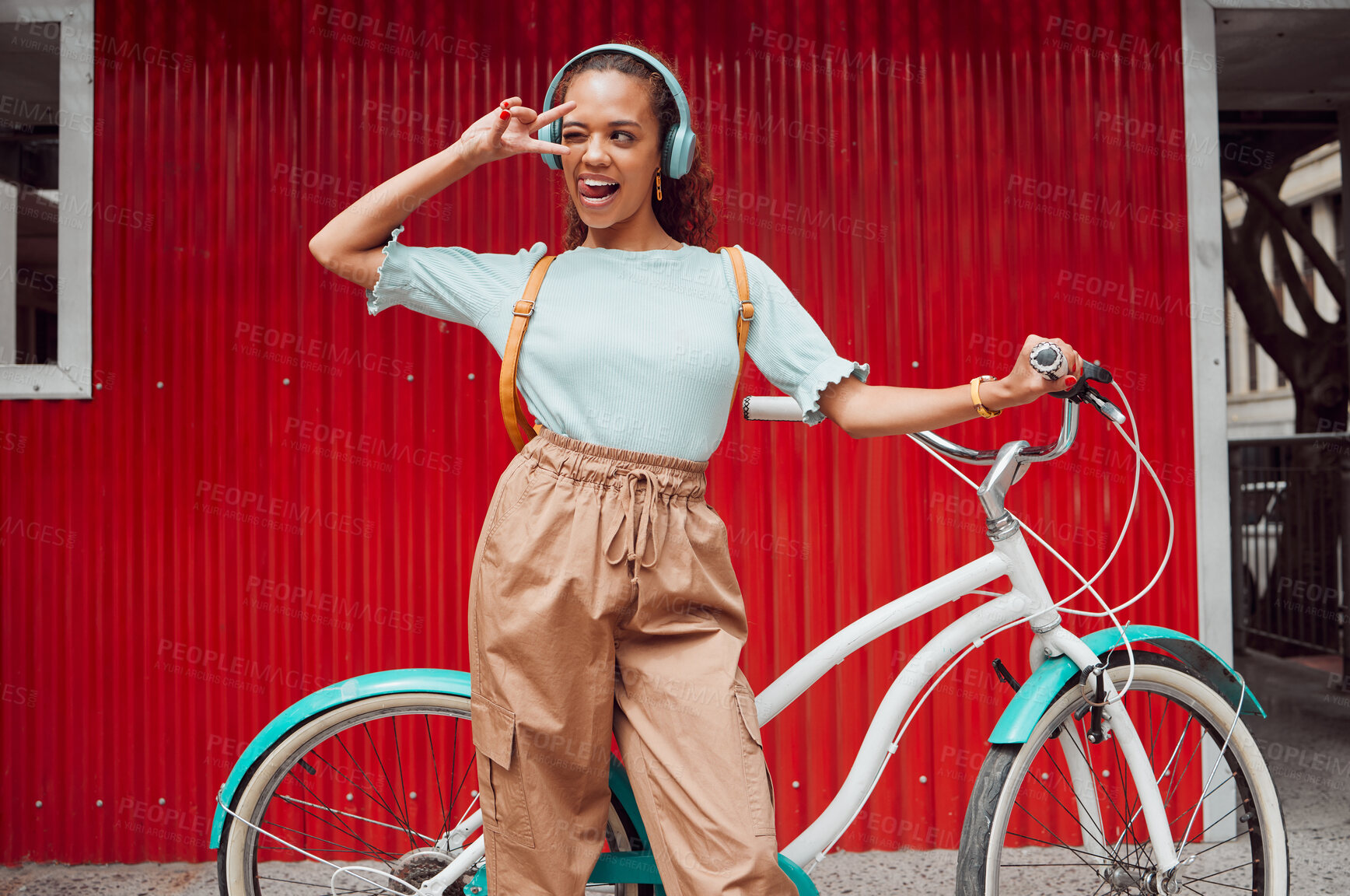 Buy stock photo Girl with bicycle in the city with peace hand sign on red background, listening to music. Summer, young and happy black woman with smile on face, bike and headphones in urban town for songs or radio