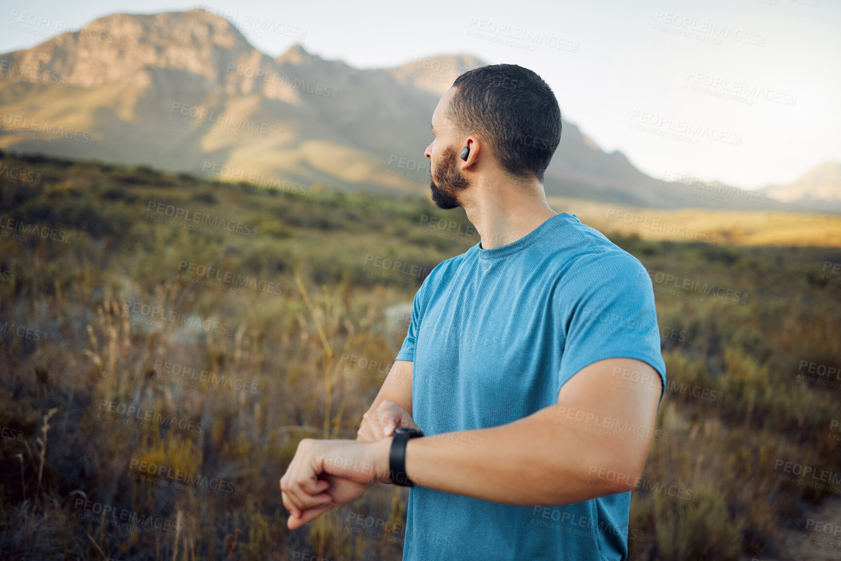 Buy stock photo Fitness, man and runner with view of mountain in nature for healthy exercise or workout in the outdoors. Active athletic male training in sports run checking time on watch in the countryside