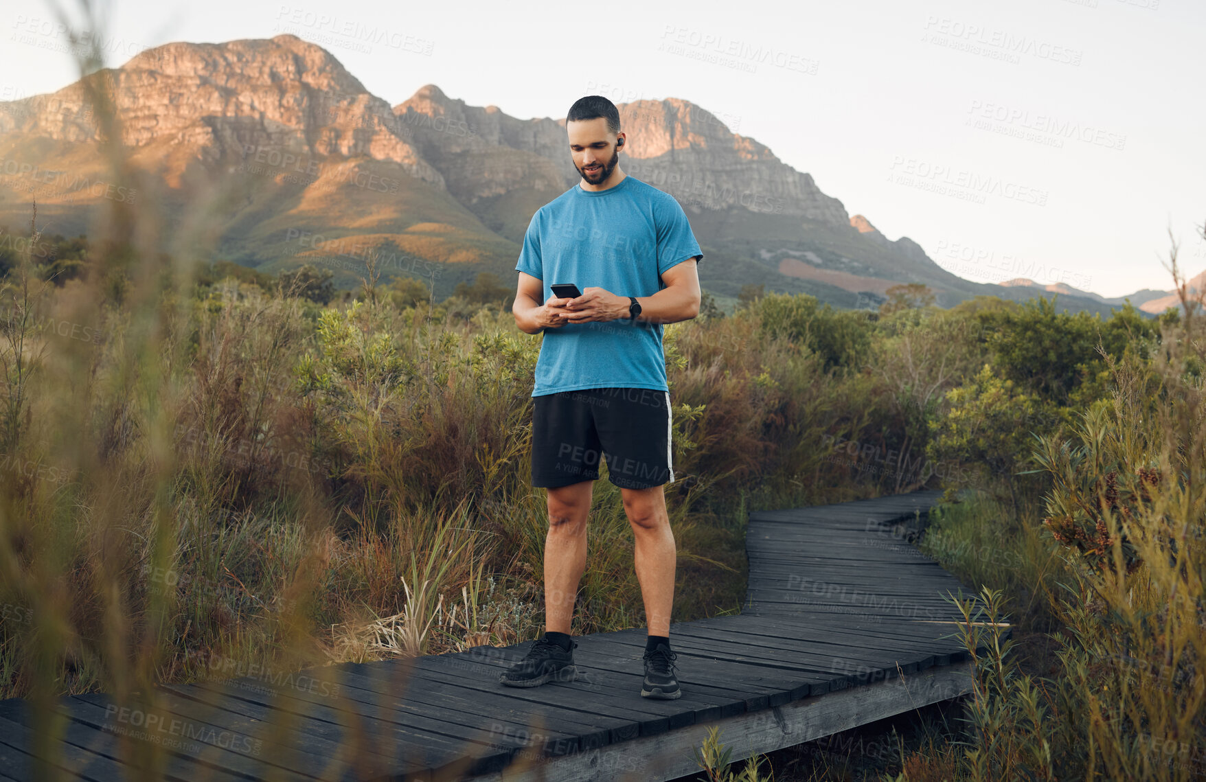 Buy stock photo Exercise, man and phone in nature for wellness, health and sportswear on running path outdoor. Workout, healthy male or trainer for fitness, break or rest with smartphone in summer with digital watch