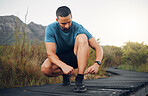 Hiking shoes, nature and man on trail to hike for wellness, health and exercise in the countryside. Forest, sports and healthy guy tying trekking boots on adventure walkway or path in South Africa.