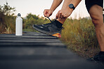 Nature, hiking shoes and man in forest for hike trip alone while on summer vacation in South Africa. Fitness, exercise and closeup of guy tying sports shoes on trekking adventure, journey or holiday.