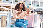 Retail, shopping and video call with black woman and phone in city for social media influencer, luxury or sales blog. Summer, store and smile with customer on bench to relax with bag, gift or fashion