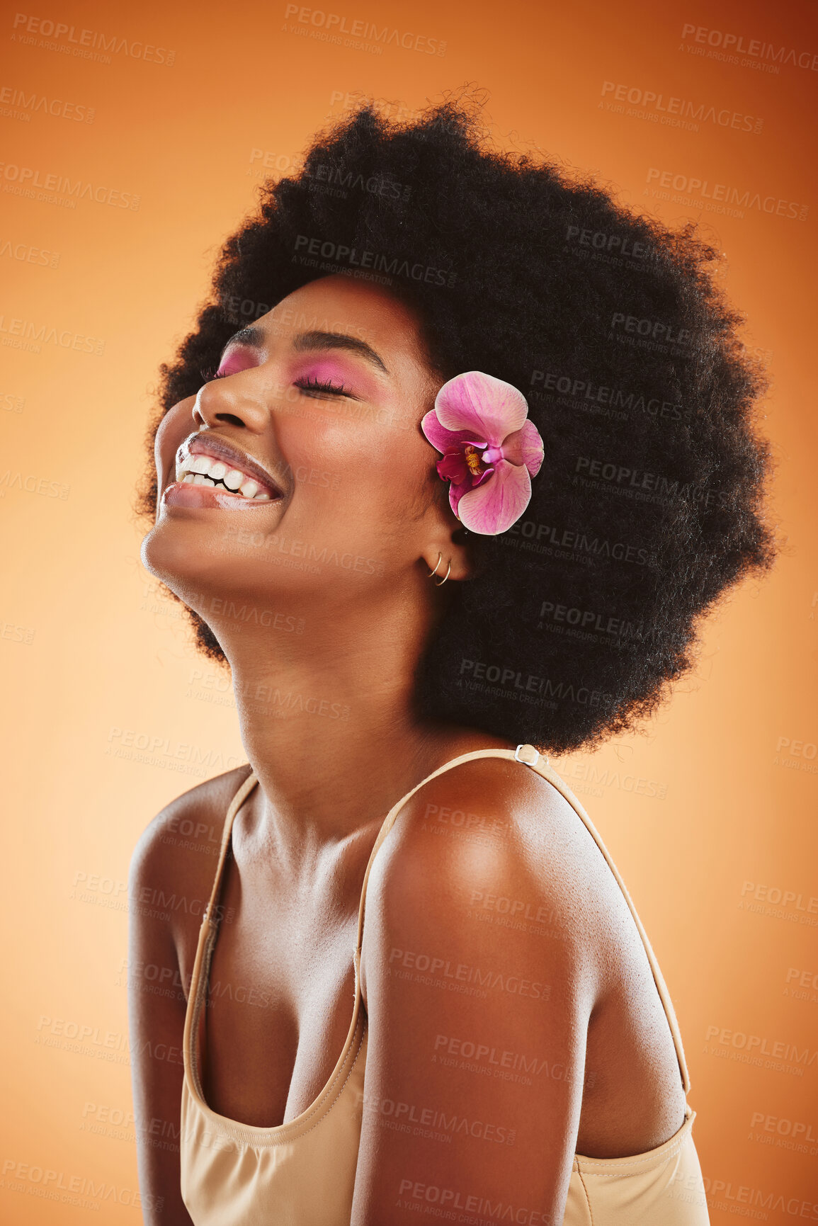 Buy stock photo Beauty, skincare and black woman with flower in afro hair wearing makeup, cosmetics and happy while laughing and satisfied with cosmetology treatment. African female model against brown background