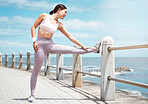 Stretching legs, fitness and woman training in nature for cardio health, body goal and wellness by the ocean. Young runner doing a warm up before running for workout, exercise and sport by the sea