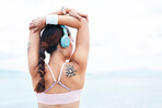 Fitness, sports and woman stretching with music on in warm up for training, cardio exercise and running workout. Tattoo, headphones and back view of girl athlete or runner ready to start challenge
