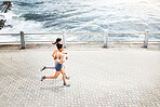 Fitness, woman and running for exercise above in workout, training and cardio in South Africa outdoors. Active women in sports run together by the ocean in sea point for healthy exercising in nature