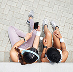 Women in city, online workout app in Miami and healthy friends relax sitting on urban floor watching fitness video. Girl streaming audio podcast, show social media exercise and outdoor 5g technology