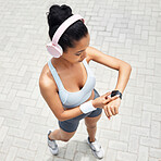 Fitness, woman and smartwatch of runner time monitoring health, performance and distance above outdoors. Active female checking watch after a run outside listening to music for training and exercise