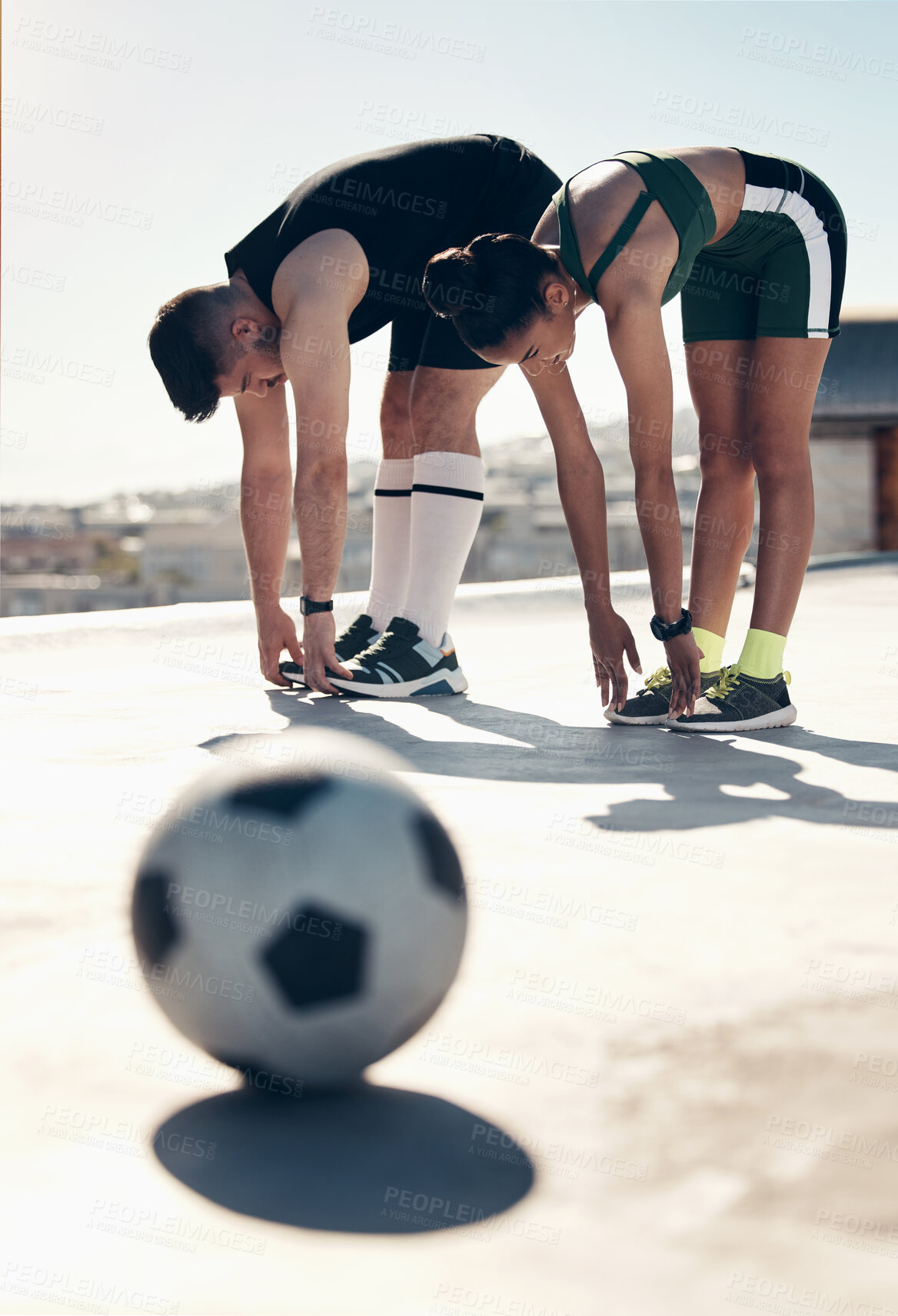 Buy stock photo Athletes stretching, soccer player and couple workout on rooftop for sports fitness exercise in summer sun. Urban sports, football player training and stretch together for cardio health cityscape run
