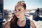 Fitness, earpods and woman in the city for outdoor workout while listening to music, podcast or radio. Training, exercise and girl athlete streaming a song or audio for sports motivation on rooftop.