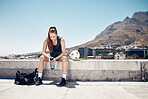 Sports athlete, woman rest on rooftop and water break after rooftop soccer training with a ball for summer fitness exercise. Urban soccer player, city roof and sweating after cardio football workout 