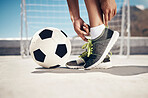 Fitness, football and feet with sport shoes standing with ball for a soccer game in summer ready to score goal. Exercise, training and practice with woman doing city workout with sneakers for fun
