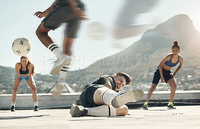 Buy stock photo Soccer, sports and tackle with a man player sliding an opponent during a game or match on a city rooftop outdoor. Football, fitness and exercise with a soccer player slide tacking for competition