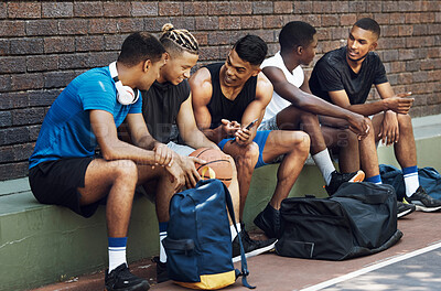 Buy stock photo Basketball, sports and phone with a team talking on a court bench after a game or match outdoor. Teamwork, technology and conversation with a man athlete group chatting after exercise or fitness