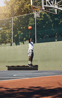 Buy stock photo Basketball, jump and athlete scoring a goal during a match or training on an outdoor court. Fitness, sports and man jumping to dunk while playing a game or doing a exercise on a basketball court.