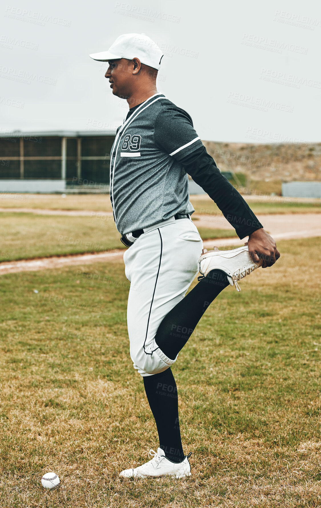 Buy stock photo Sports, baseball athlete and man stretching on grass field for game, fitness exercise or competition warm up. Health, wellness and person prepare for start of training, workout or cardio performance