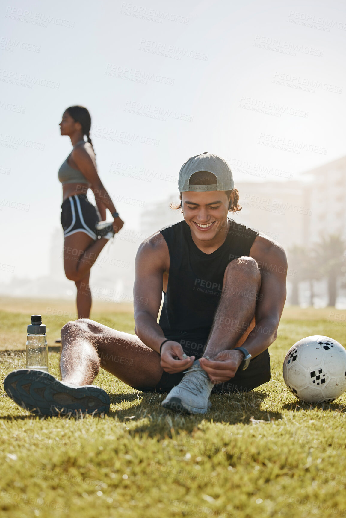 Buy stock photo Friends, sport and fitness, stretching on grass with soccer ball, warm up for exercise and workout outdoor in park. Young man tying shoe lace, black woman and sports training with body wellness.