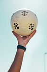 Hand, soccer ball and sport motivation for football, fitness and exercise isolated against a blue sky background. Hands of active athlete holding ball in sports training, achievement or trophy win