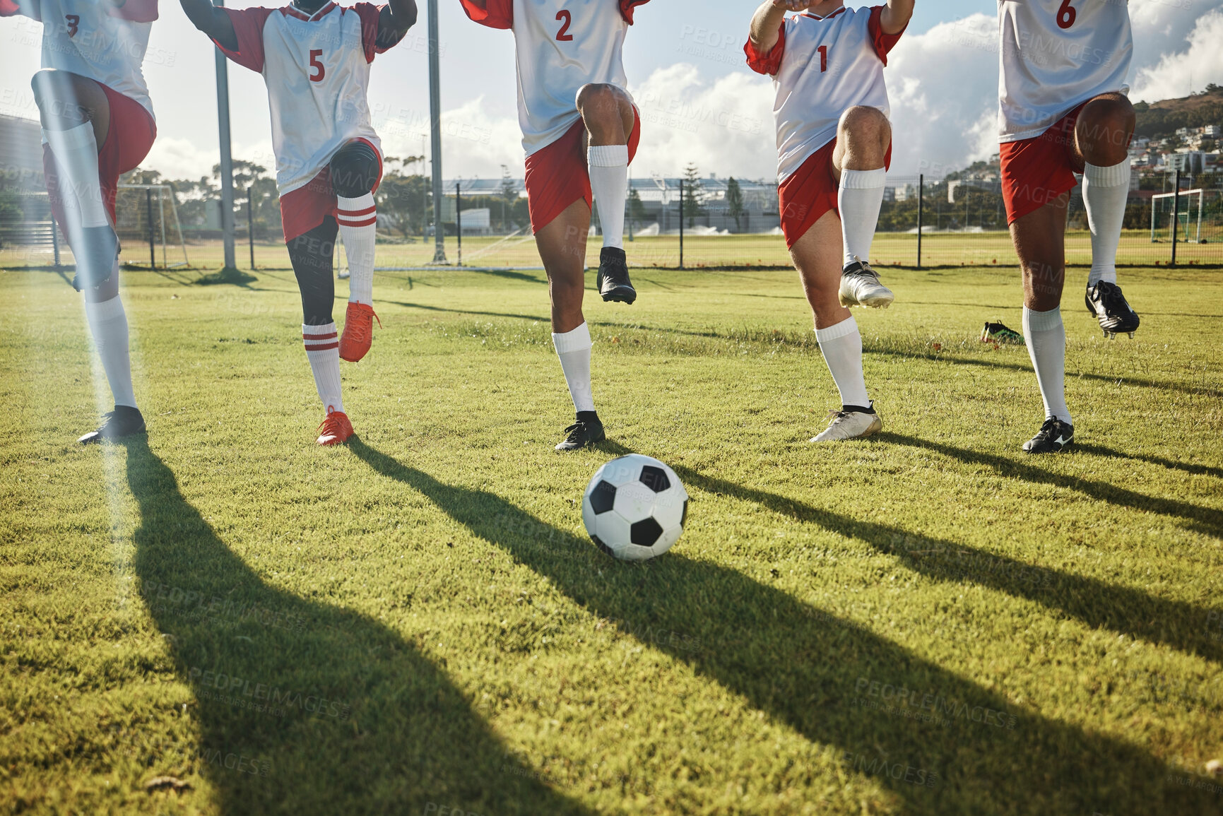 Buy stock photo Football, soccer field and team stretching legs preparing for match, practice or game. Ball, sports and group of men outdoors on pitch getting ready for training, exercise or fitness workout outside.