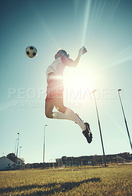 Buy stock photo Soccer, sports and training with a man athlete jumping with a ball on a field or grass pitch for exercise. Fitness, football and workout with a male soccer player playing in a game or match outdoor