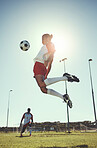 Soccer, sports and training with a man athlete playing with a ball on a field or grass pitch for exercise and fitness. Football, jumping and workout with a male in a game or match for sport