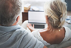 Couple, retirement and pensioner with a senior man and woman watching tv on a laptop in their living room together. Love, entertainment and bonding with an elderly husband and wife streaming online
