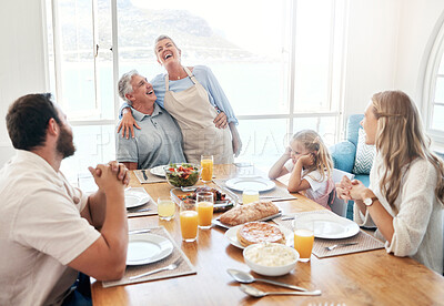 Buy stock photo Breakfast, communication and big family eating food together at the dining room table of their house. Senior man and woman speaking about funny story during lunch with children in their home