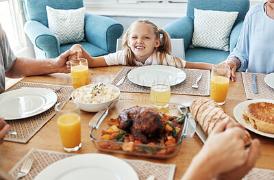 Buy stock photo Food, family and praying with girl at a table, holding hands in gratitude, prayer and bonding before eating. Worship, pray time and child looking curious, hungry and playful while looking at a meal