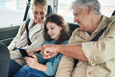 Buy stock photo Child, grandparents and phone on road trip in car backseat streaming movie, elearning or helping with education game. Child, man and woman uber happy on travel journey and checking destination online