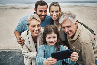 Buy stock photo Family, beach and smile for phone selfie together for quality bonding time, holiday or vacation in the outdoors. Happy parents, grandparents and child smiling for photo on smartphone at the ocean