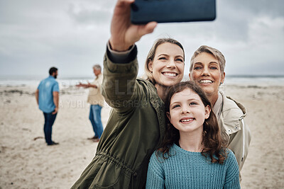 Buy stock photo Phone, selfie and beach with a girl, mother and grandmother taking a family photograph on the sand by the sea while on vacation. Summer, technology and love with female relatives posing for a picture