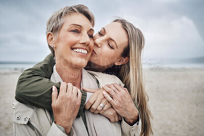 Buy stock photo Kiss, mother and daughter at beach smile, hug and kiss with smile together in Australia. Happy face of young woman with a senior mom in the sea or ocean together with love and to relax in happiness
