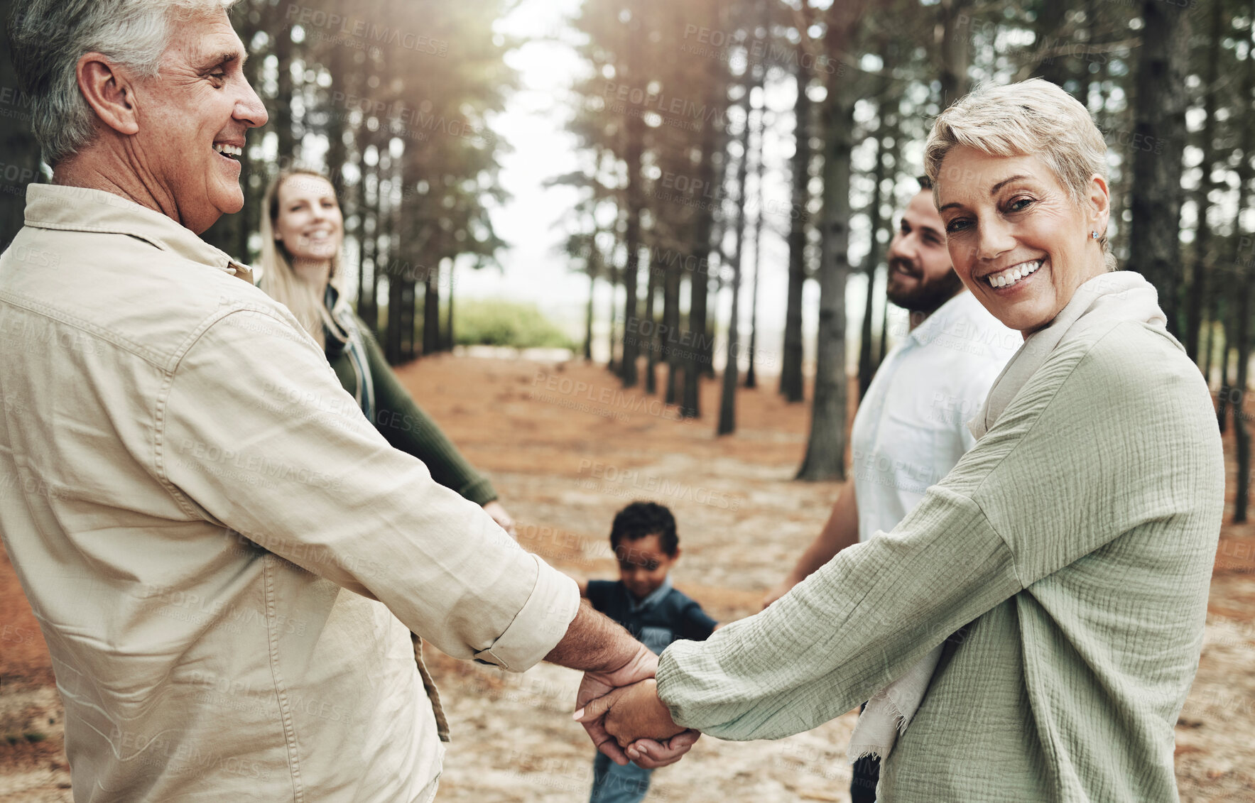 Buy stock photo Diversity, holding hands and family on forest nature walk for bonding, wellness or healthy outdoor holiday. Senior, elderly grandparents portrait for interracial love, care and trust on fun adventure