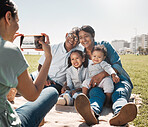 Grandparents, children and mother with photo on a phone in park together during summer. Relax, happy and smile from kids and senior man and woman with picture on mobile from mom in nature by the sea