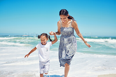 Buy stock photo Beach, mother and girl being happy, relax and playful for summer, vacation and holding hands together. Mama, child and daughter being joyful, enjoy seaside and smile while on travel for bonding.