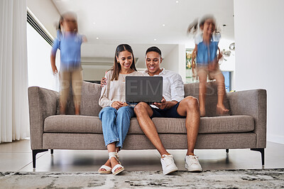 Buy stock photo Busy, children and parents streaming a movie on the internet with a laptop on the living room sofa in house. Man and woman with a show on a computer while kids play and jump with energy on the couch