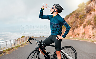 Cyclist, drinking water or fitness break on road in workout, training or exercise in competition race, health wellness. Sports man, bike athlete or thirsty cycling person on France countryside street