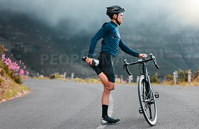 Sports, fitness and man stretching in a road during cycling workout, training and focus in nature. Bike, sport and performance preparation by athletic cyclist doing leg stretch before exercise
