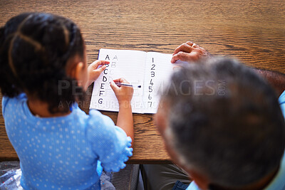 Buy stock photo Education, homework and family with a girl and father writing in a notebook for school, learning or development. Study, help and student with a female child studying with her dad at home from above