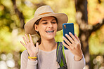 Nature, hike and phone video call of a woman in nature talking and hiking outdoor. Happy smile of a person wave in a mobile conversation using 5g internet and technology on a tree forest walk 