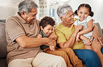 Family, happy and grandparents with children on sofa playing tickle game for bonding fun in home. Love, care and joyful smile together in Mexico family home with grandma, grandfather and kids.


