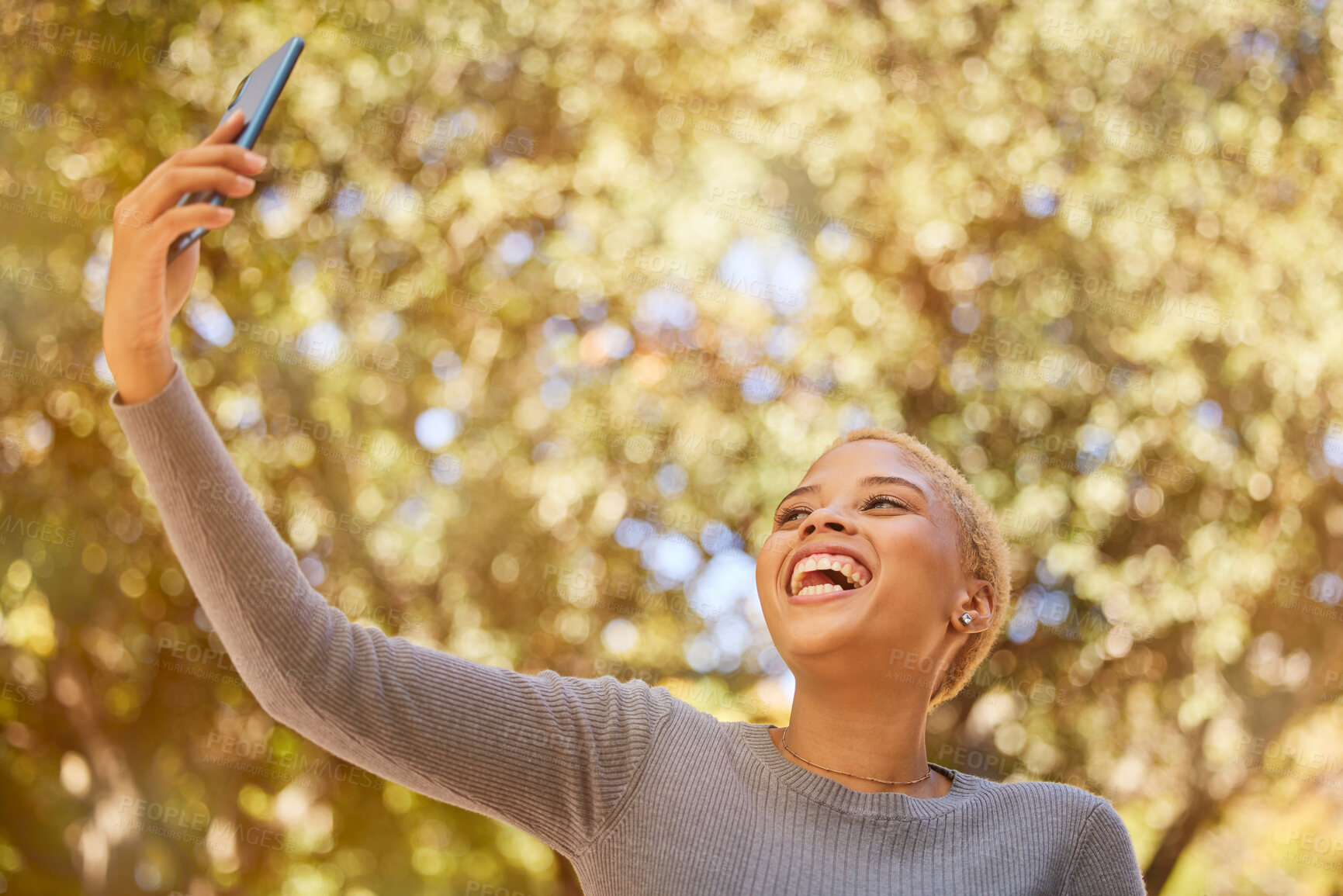 Buy stock photo Selfie, phone and young woman, smile and social media, laugh while outdoor in nature and happy. Gen Z girl from mexico and 5g technology, photo and youth, walking outside in garden or park in autumn 