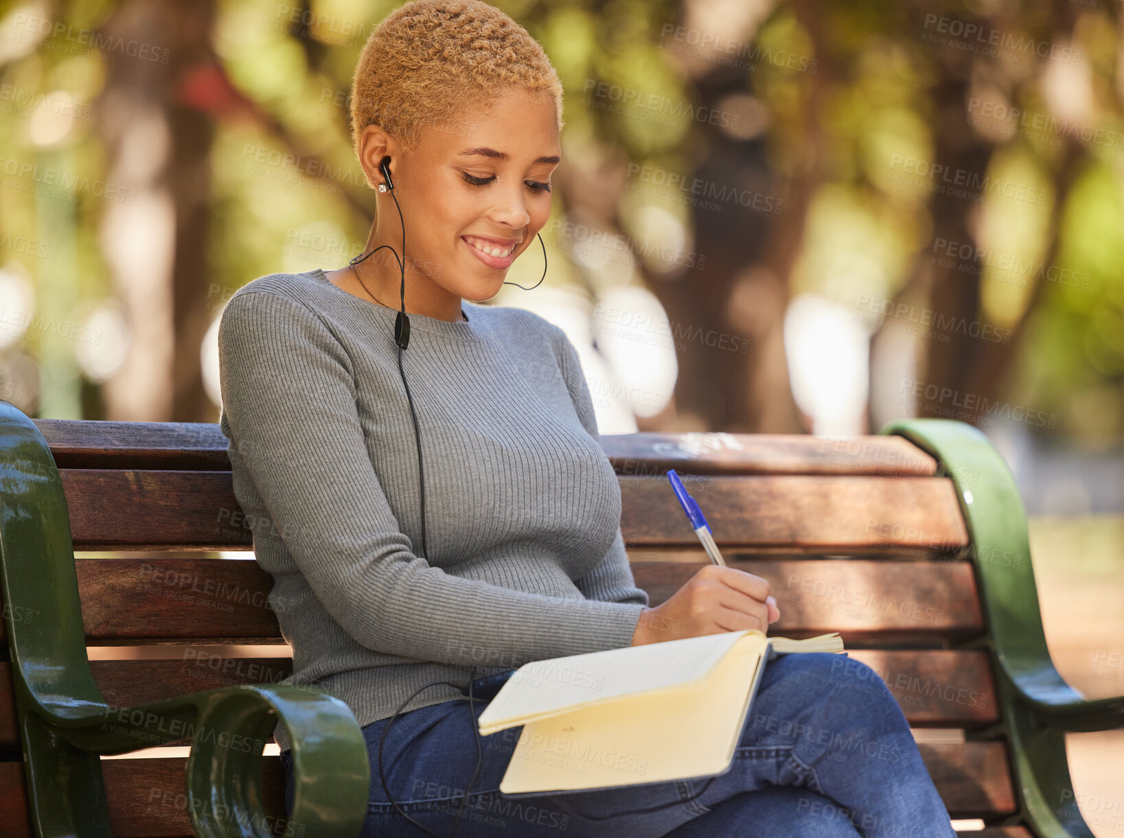 Buy stock photo Happy, black woman and writer outdoor with music to relax, enjoy sunny day and make notes for studies. Young female, lady student with notebook and podcast, writing in diary or journal outside.