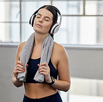 Towel, tired or fitness woman with music headphones in gym workout, health training or wellness exercise for heart cardio. Sweating, exhausted or fatigue sports person listening to motivation radio
